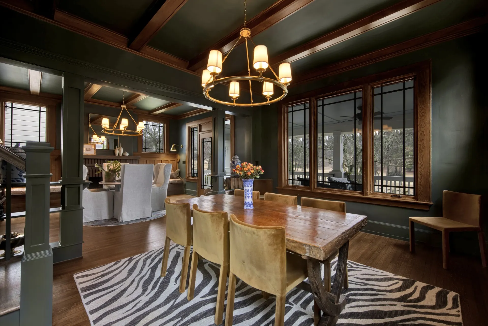 Historic Birmingham dining room with coffered ceiling, green paneling and brass chandeliers